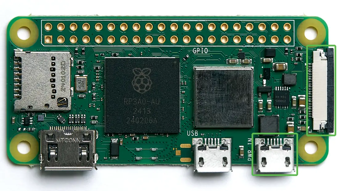 Top of a Raspberry Pi Zero 2 W. One green box marks the thin camera connector on the short right edge. Another marks the micro-USB port labelled PWR IN.
